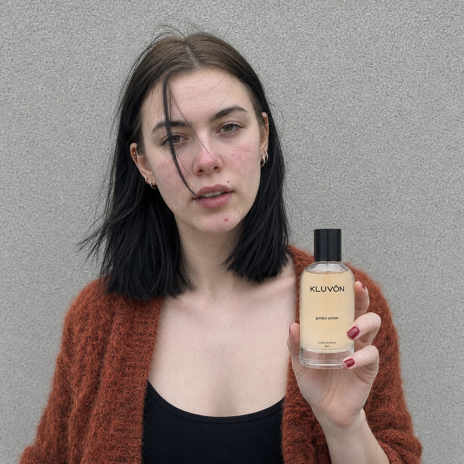 Kvinde i rust cardigan med Kluvon golden ember extrait de parfum